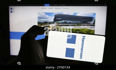 Stuttgart, Germania, 03-16-2024: Persona che detiene un telefono cellulare con il logo della società immobiliare britannica Hammerson plc di fronte alla pagina web aziendale. Messa a fuoco o Foto Stock