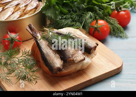 Delizioso panino con spratti e aneto servito su un tavolo di legno azzurro, primo piano Foto Stock