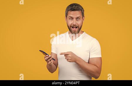 un uomo stupito controlla la chat di comunicazione con lo smartphone. concetto di comunicazione. Foto Stock
