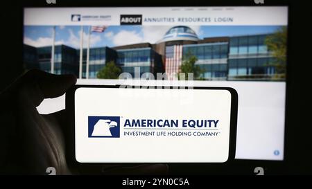 Stoccarda, Germania, 07-01-2024: Persona che detiene un cellulare con il logo della American Equity Investment Life Holding Company davanti alla pagina web aziendale. Fil Foto Stock
