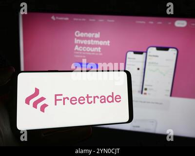Stoccarda, Germania, 03-15-2024: Persona che detiene un telefono cellulare con il logo della società britannica Freetrade Ltd. Di fronte alla pagina web aziendale. Messa a fuoco o Foto Stock