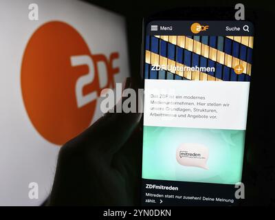 Stoccarda, Germania, 04-10-2024: Persona con smartphone e pagina web dell'emittente televisiva Zweites Deutsches Fernsehen (ZDF) con logo. Concentrati su Foto Stock