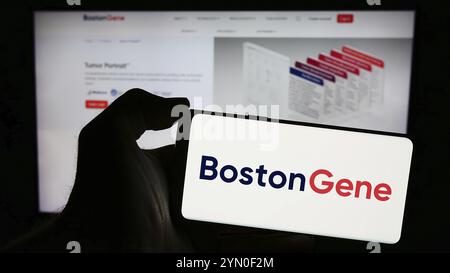 Stoccarda, Germania, 03-28-2024: Persona che detiene il cellulare con il logo della società statunitense di biotecnologie BostonGene Corporation di fronte alla pagina web aziendale. Fil Foto Stock