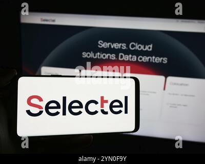Stoccarda, Germania, 04-08-2024: Persona che detiene un cellulare con il logo della società russa di infrastrutture cloud Selectel Ltd. Di fronte alla pagina web aziendale. Foto Stock