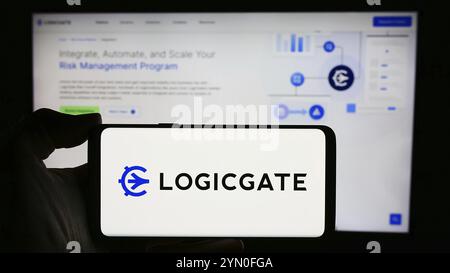 Stoccarda, Germania, 04-05-2024: Persona che detiene un cellulare con il logo della società statunitense LogicGate Inc. Di fronte alle pagine web aziendali Foto Stock