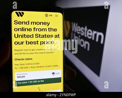 Stoccarda, Germania, 05-27-2024: Persona che possiede uno smartphone con pagina Web dell'azienda statunitense di servizi finanziari The Western Union Company con logo. Concentrati su Foto Stock