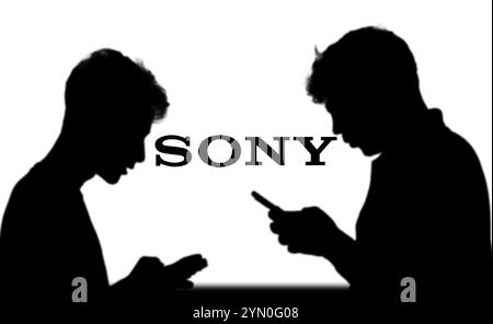SONY è una società giapponese. SONY è un'azienda produttrice di console di videogiochi e di videogiochi. Smartphone con logo SONY sullo schermo circondato da gamepad. Foto Stock