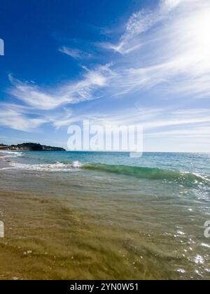 Vista mare con onde dolci che si innalzano sulla spiaggia sabbiosa Foto Stock