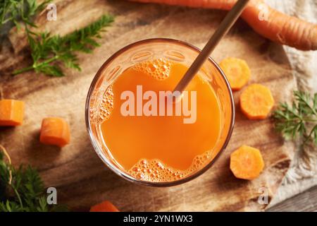 Un bicchiere di succo di carota fresco con cannuccia di carta riciclabile. Zero sprechi. Foto Stock