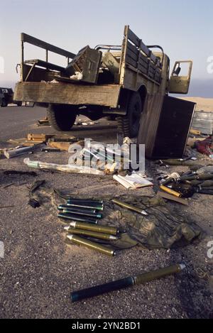 Prima guerra del Golfo: 11 marzo 1991. Testate e booster di granate a propulsione RPG-7 sparse nel deserto dietro un piccolo camion carico di casse di munizioni sulla Route 801, la strada per um Qasr, nel nord-est del Kuwait. Foto Stock