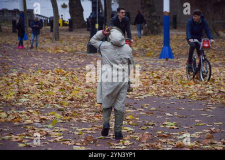 Londra, Regno Unito. 24 novembre 2024. Le persone camminano lungo il centro commerciale coperto di foglie cadute mentre Storm Bert porta forti venti nella capitale. Crediti: Vuk Valcic/Alamy Live News Foto Stock