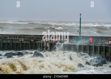 West Bay, Dorset, Regno Unito. 24 novembre 2024. Le persone si rinfrescano dopo aver utilizzato la sauna Bayside a West Bay mentre la tempesta Bert crea enormi onde sulla costa del Dorset. Credito: Tom Corban/Alamy Live News Foto Stock