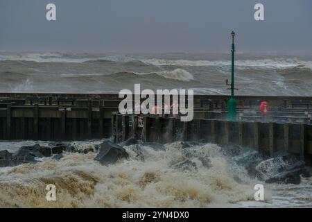 West Bay, Dorset, Regno Unito. 24 novembre 2024. Le persone si rinfrescano dopo aver utilizzato la sauna Bayside a West Bay mentre la tempesta Bert crea enormi onde sulla costa del Dorset. Credito: Tom Corban/Alamy Live News Foto Stock