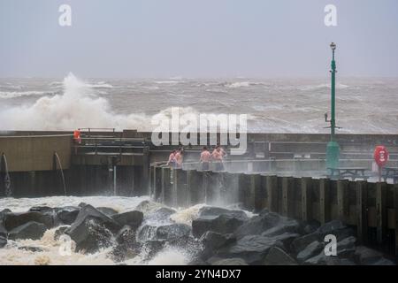 West Bay, Dorset, Regno Unito. 24 novembre 2024. Le persone si rinfrescano dopo aver utilizzato la sauna Bayside a West Bay mentre la tempesta Bert crea enormi onde sulla costa del Dorset. Credito: Tom Corban/Alamy Live News Foto Stock