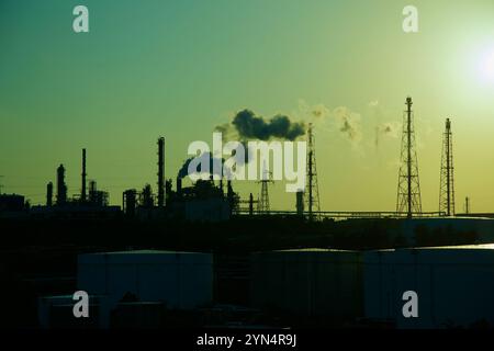 Ulsan, Corea del Sud - 14 novembre 2024: Una vista sagomata del complesso industriale di Yongyeon durante il tramonto, con le ciminiere che emettono pennacchi nel Foto Stock