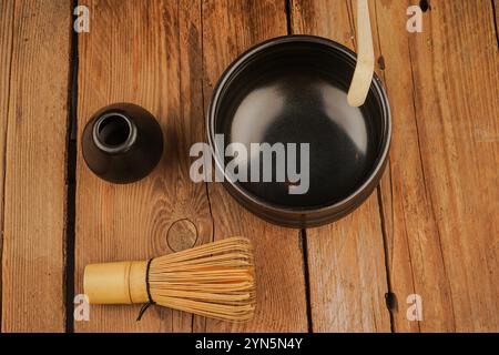 Classica frusta matcha di bambù su una superficie in legno decorata con accessori per il tè. Come concetto di cultura del tè, vita lenta e relax naturale Foto Stock
