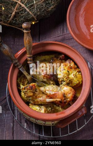 Coniglio con erbe, timo e rosmarino e aglio in salsa di panna acida, cotto in una pentola di argilla. Foto Stock