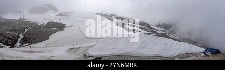 Una grande tela bianca che protegge il ghiaccio del ghiacciaio dell'Hintertux nelle Alpi, una pista da sci conduce tra l'Austria e l'Europa Foto Stock