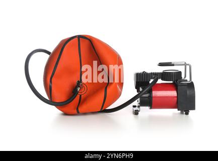 Sfera da basket sgonfiata e compressore d'aria isolato su bianco Foto Stock