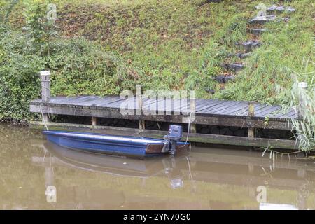 Piccola barca blu sul molo di legno Foto Stock