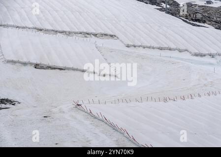 Una grande tela bianca che protegge il ghiaccio del ghiacciaio dell'Hintertux nelle Alpi, una pista da sci conduce tra l'Austria e l'Europa Foto Stock