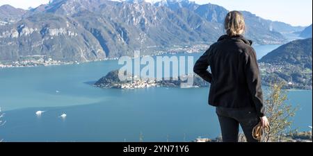 Un escursionista che gode della magnifica vista di Bellagio sul lago di Como vista da Monte Crocione, Italia, Europa Foto Stock