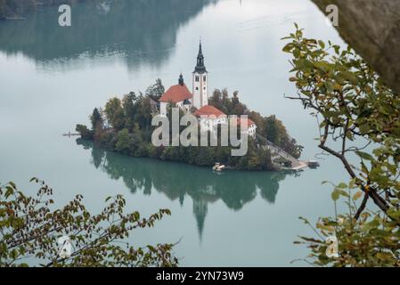 Tranquilla vista sul lago di Bled e l'isola con la sua chiesa di pellegrinaggio Assunzione di Maria, le Alpi slovene Foto Stock