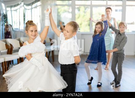 Entusiasti bambini preadolescenti che ballano valzer a coppie nella scuola di danza Foto Stock
