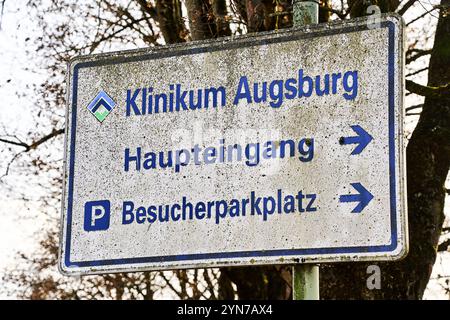 Augusta, Baviera, Germania - 24 novembre 2024: Cartello per l'ospedale di Augusta con le indicazioni per l'ingresso principale e il parcheggio per i visitatori *** Beschilderung für das Klinikum Augsburg mit Hinweisen zum Haupteingang und Besucherparkplatz Foto Stock