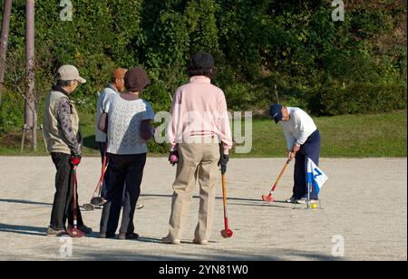 Gruppo di anziani giapponesi che giocano a "gateball" (croquet) in un pomeriggio di sole a Hikone, prefettura di Shiga, Giappone. Foto Stock