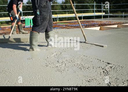 Lavoratori che riempiono il terreno del secondo piano con edifici in cemento, anima e guscio Foto Stock