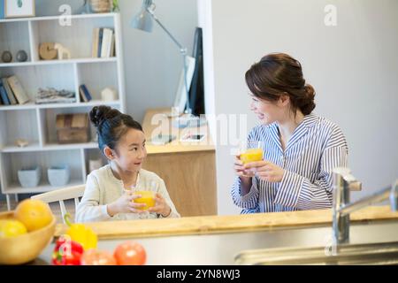 Genitori e bambini sorridenti che bevono succo d'arancia in camera Foto Stock