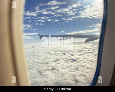 Vista dalla finestra aereo sopra le nuvole Foto Stock