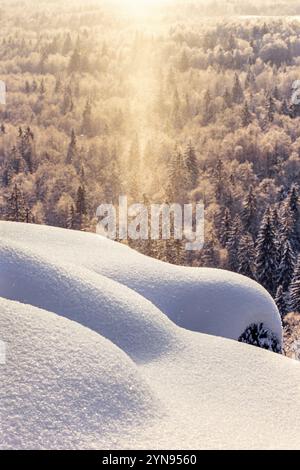 Prendi il sole sopra una foresta e un passaggio di neve in inverno Foto Stock
