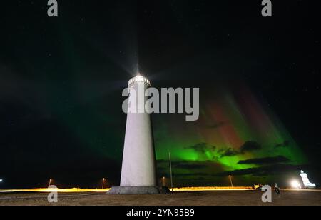 L'aurora boreale, nota anche come aurora boreale, visibile sopra il faro di New Gardur, builit nel 1944 sul punto settentrionale della penisola di Reykjanes in Islanda. Data foto: Domenica 24 novembre 2024. Foto Stock