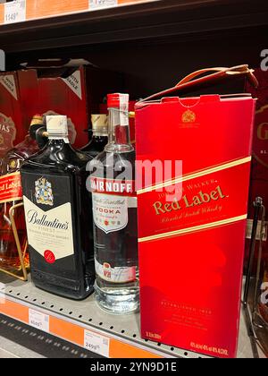 Kiev, Ucraina - 24 novembre 2024: Una selezione di bottiglie di whisky e vodka, tra cui Johnnie Walker e Smirnoff su uno scaffale al dettaglio, che mostra popolari Foto Stock