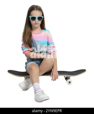 Elegante ragazza con occhiali seduti sullo skateboard su sfondo bianco Foto Stock