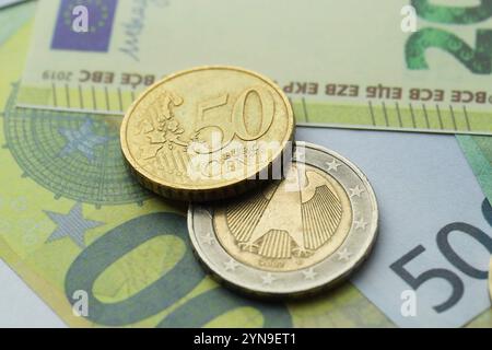 Monete diverse sulle banconote in euro, vista ravvicinata Foto Stock