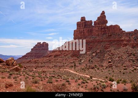 Vista mozzafiato della Valle degli dei dello Utah, caratterizzata da maestose formazioni di roccia rossa sotto un cielo azzurro. Una tortuosa strada sterrata che attraversa il canyon Foto Stock