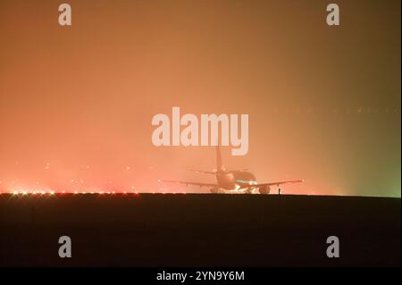 Un piano sulla pista di East Midlands Airport in condizioni di nebbia. Foto Stock