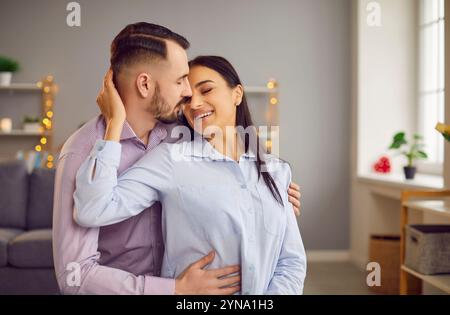 Felice coppia di famiglie che abbraccia il soggiorno Foto Stock