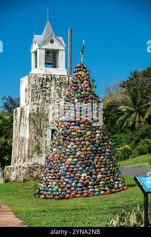 Colorata torre di pietra vicino all'edificio storico nel giardino tropicale nelle giornate di sole Foto Stock