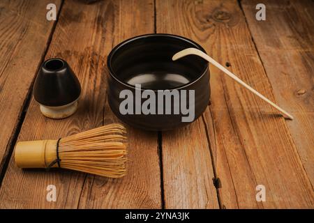 Classica frusta matcha di bambù su una superficie in legno decorata con accessori per il tè. Come concetto di cultura del tè, vita lenta e relax naturale Foto Stock
