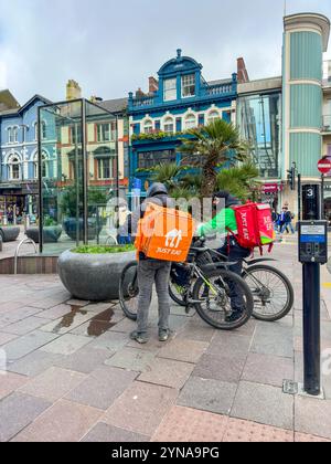 Corrieri di consegna fast food nel centro di Cardiff, Galles 2023 Foto Stock