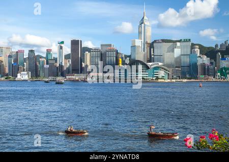 Hong Kong - 13 luglio 2017: Piccole imbarcazioni con passeggeri navigano sul mare di fronte al quartiere centrale della città di Hong Kong in un giorno d'estate Foto Stock