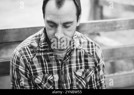 Uomo di mezza età con capelli facciali, con camicia a quadri in bianco e nero Foto Stock