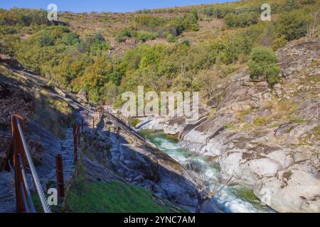 Percorso semi-scavato nella roccia con il ponte pedonale Los Pilones sul fondo. Estremadura, Spagna Foto Stock