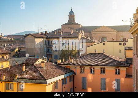 Storico paesaggio urbano di Bologna città medievale in Emilia Romagna, Italia, con tetti in terracotta, facciate colorate e la cupola di una chiesa sotto soffice Foto Stock