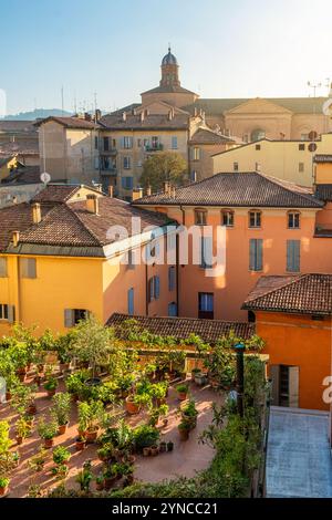 Paesaggio storico della città medievale di Bologna in Emilia Romagna, Italia, con tetti in terracotta, facciate colorate e giardino sul tetto con una varietà di Foto Stock