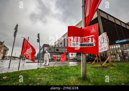 Duisburg, Germania. 25 novembre 2024. Poster e bandiere IG Metall di fronte all'ingresso del sito dell'acciaio ThyssenKrupp a Duisburg. La più grande azienda siderurgica tedesca, ThyssenKrupp Steel Europe, prevede di tagliare diverse migliaia di posti di lavoro nei prossimi anni. Crediti: Christoph Reichwein/dpa/Alamy Live News Foto Stock